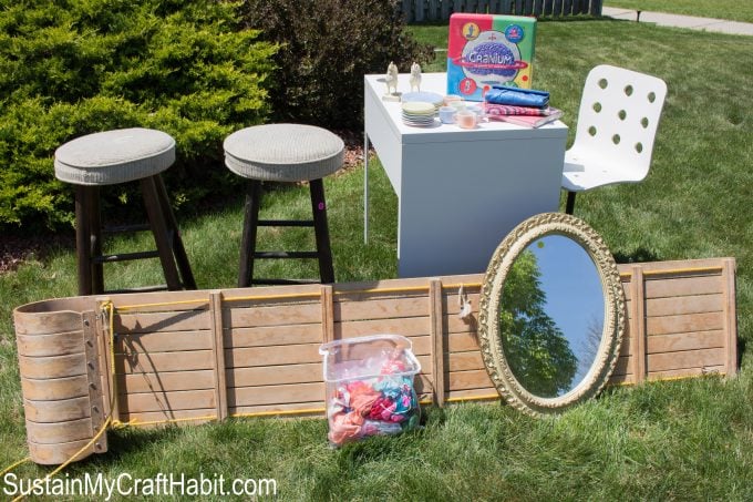 Collection of items picked up at yard sales including a large wooden sled, two upholstered bar stools, oval mirror, small office desk and chair, games and others.