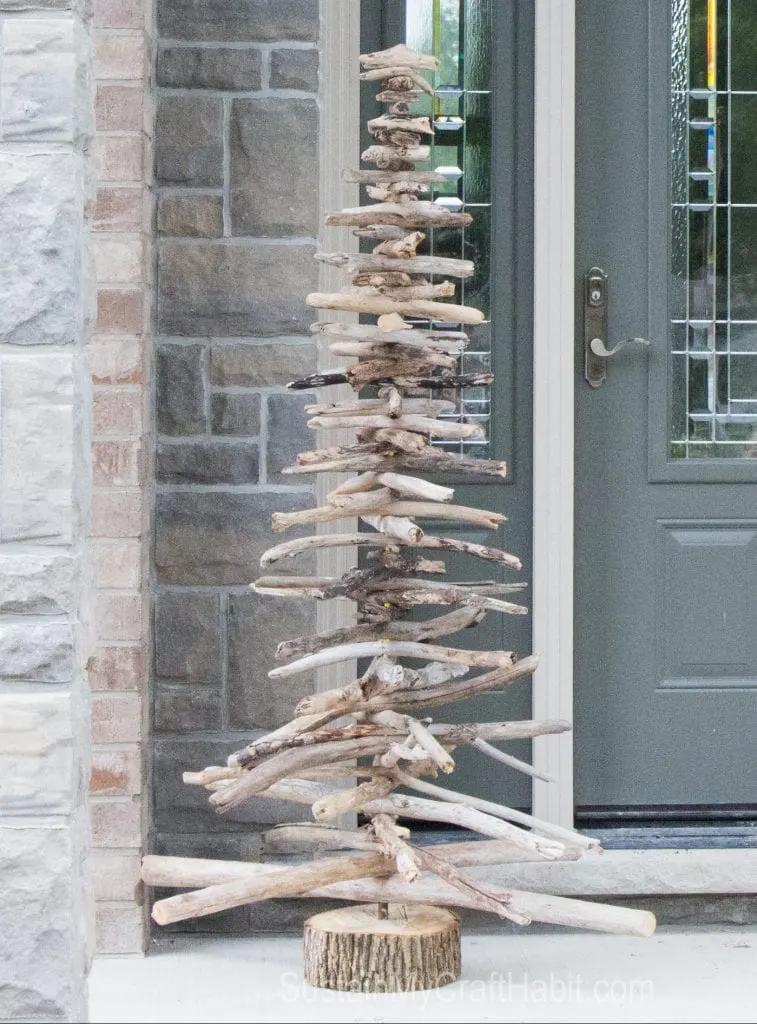 A 6-foot tall DIY driftwood Christmas tree on the front porch of a home