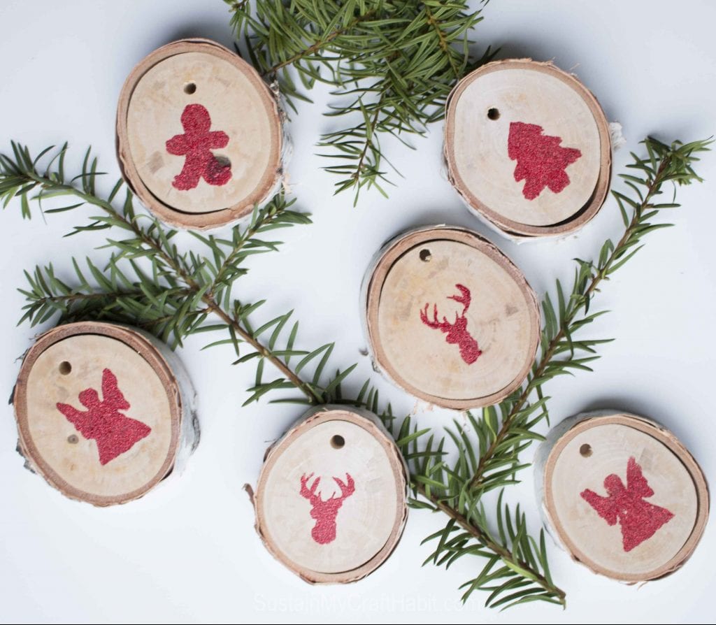 Create beautiful and rustic wood slice ornaments with a bit of red glitter. Great to decorate your home, Christmas tree or gift bags!