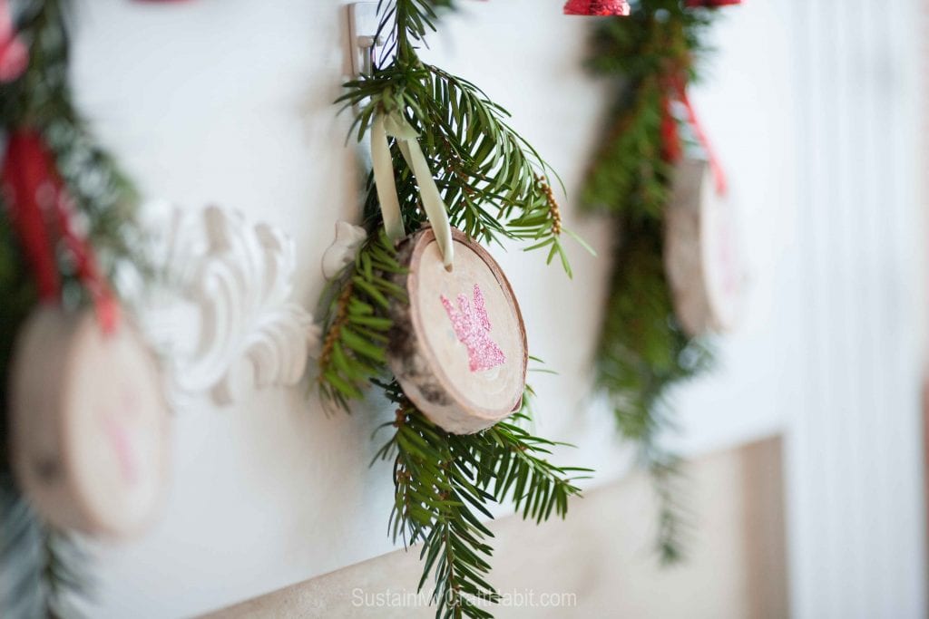 Create beautiful and rustic wood slice ornaments with a bit of red glitter. Great to decorate your home, Christmas tree or gift bags!