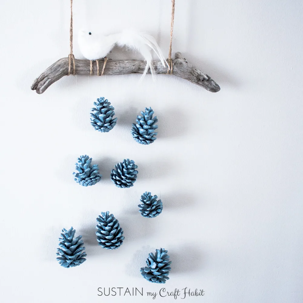 A beautiful bird perched above a cascading array of robin's egg blue pinecones makes a beautiful, inexpensive and easy rustic DIY wall art idea. Check out the detailed step-by-step tutorial.
