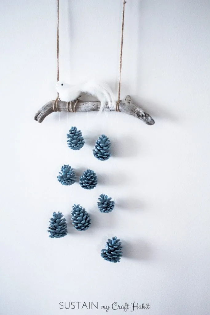 A beautiful bird perched above a cascading array of robin's egg blue pinecones makes a beautiful, inexpensive and easy rustic DIY wall hanging idea. Check out the detailed step-by-step tutorial.