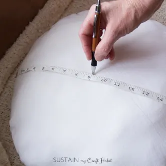 Measuring and marking the center of a round pillow form to create a pucker for the crochet pillow cover