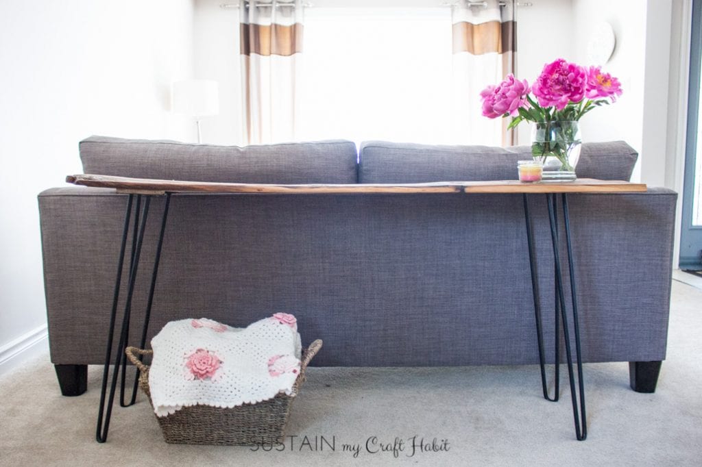 Full view of the sofa table made with a piece of barn wood and hairpin legs