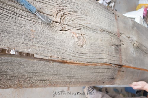 Prying off a splintered end of barn board to make a DIY console table