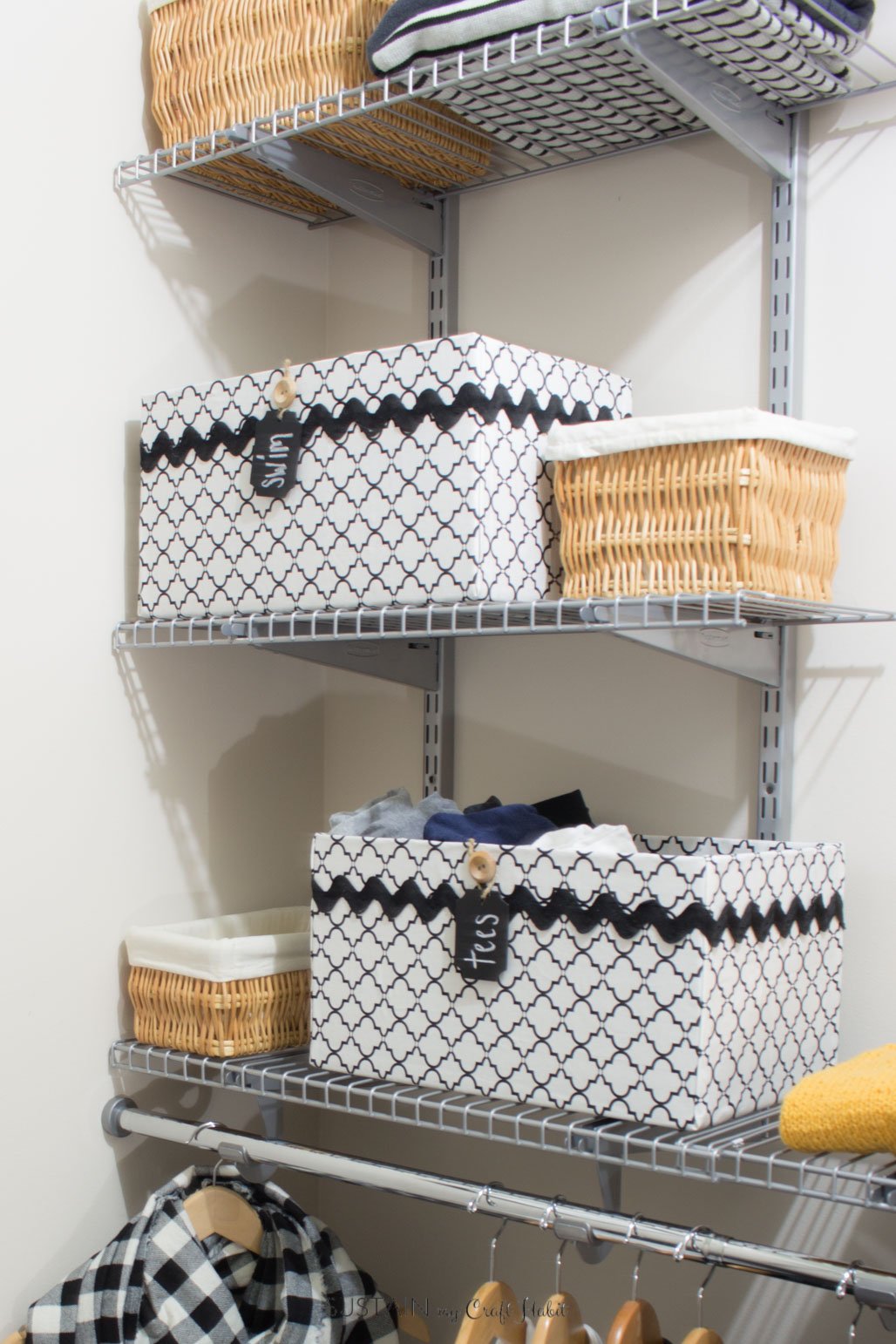 The completed fabric-covered storage boxes arranged on a wire shelving unit in a closet.