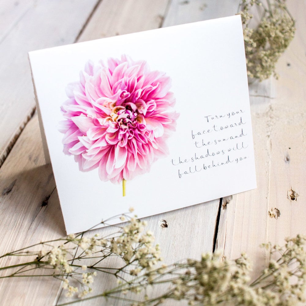 Pink dahlia greeting card template on a wooden surface