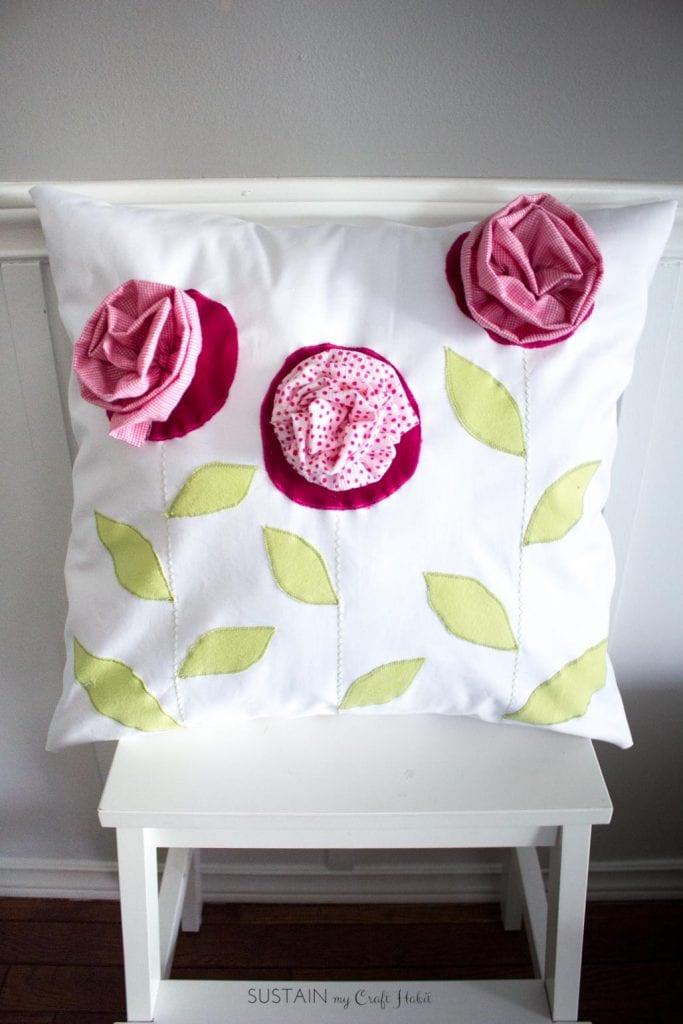 Throw pillow made with outgrown baby clothing. A DIY upcycling handmade gift idea.