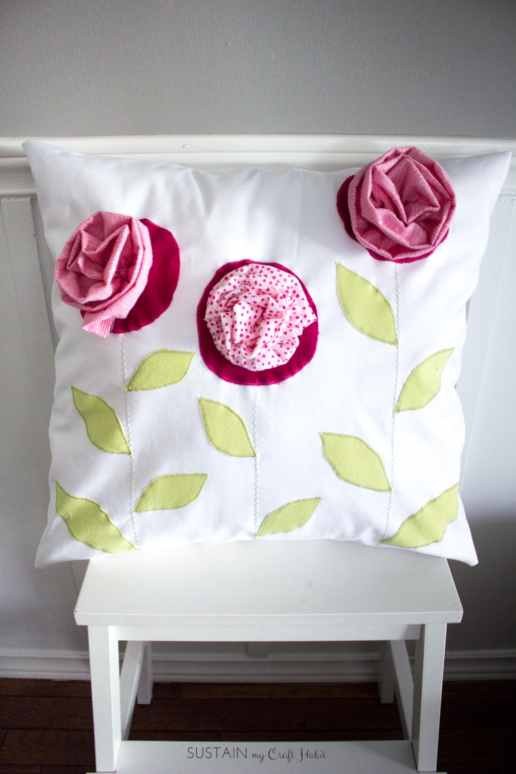 Throw pillow made with outgrown baby clothing. A DIY upcycling handmade gift idea.