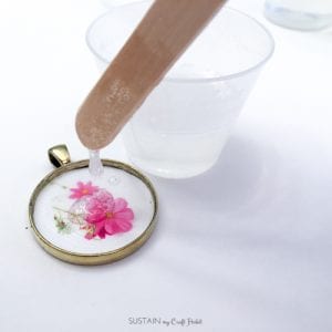 Step by step tutorial on how to make resin jewelry with a flower image