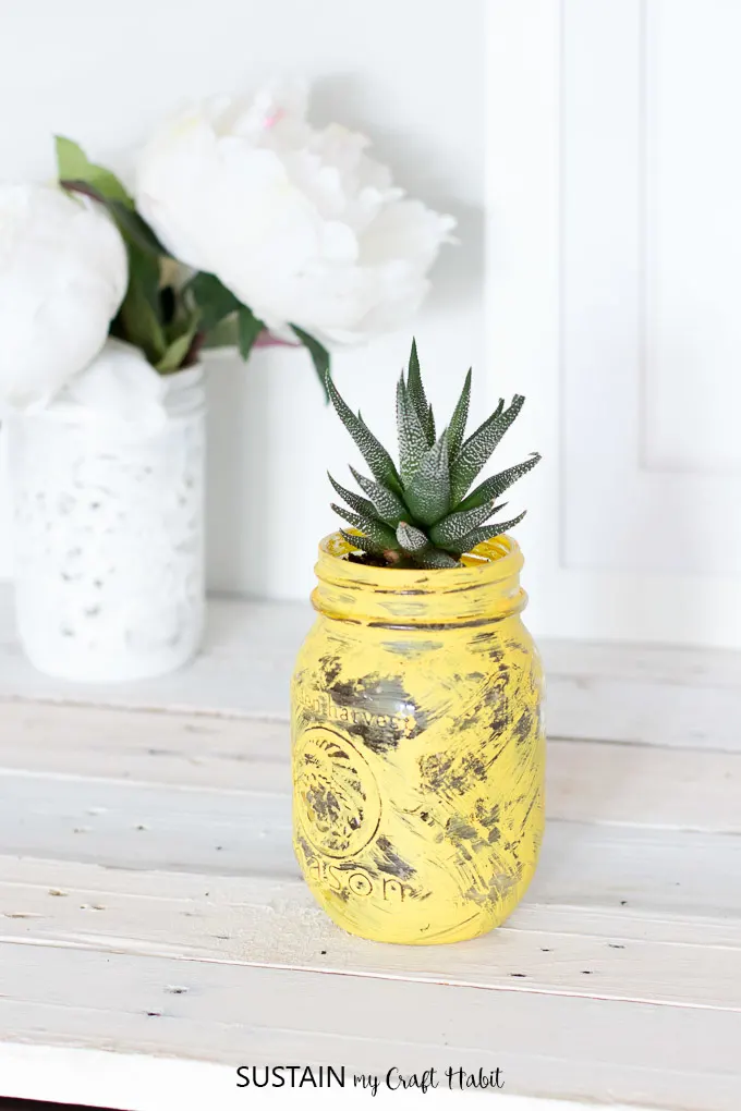 Upcycle a small mason jar into an adorable pineapple succulent planter. Hop on the pineapple trend with this simple DIY idea. Full tutorial with video included!