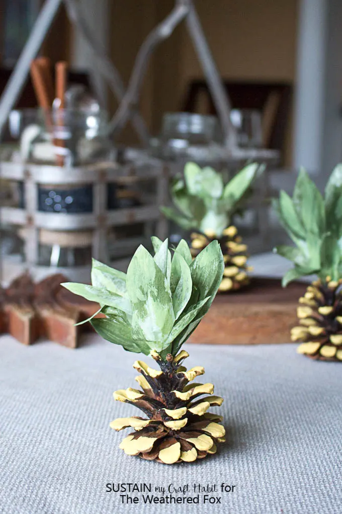Adorable pineapple party idea! Make your own pineapple napkin weights with pine cones. Tips and tricks for cleaning pinecones for crafting.