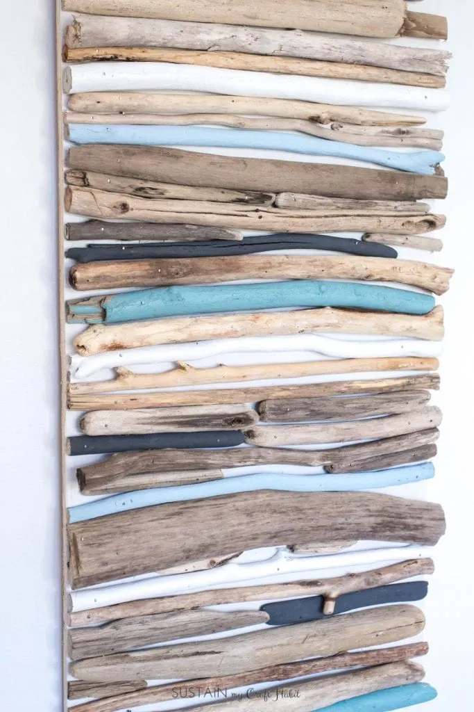 Wall art made with driftwood pieces painted in various shades of blue.