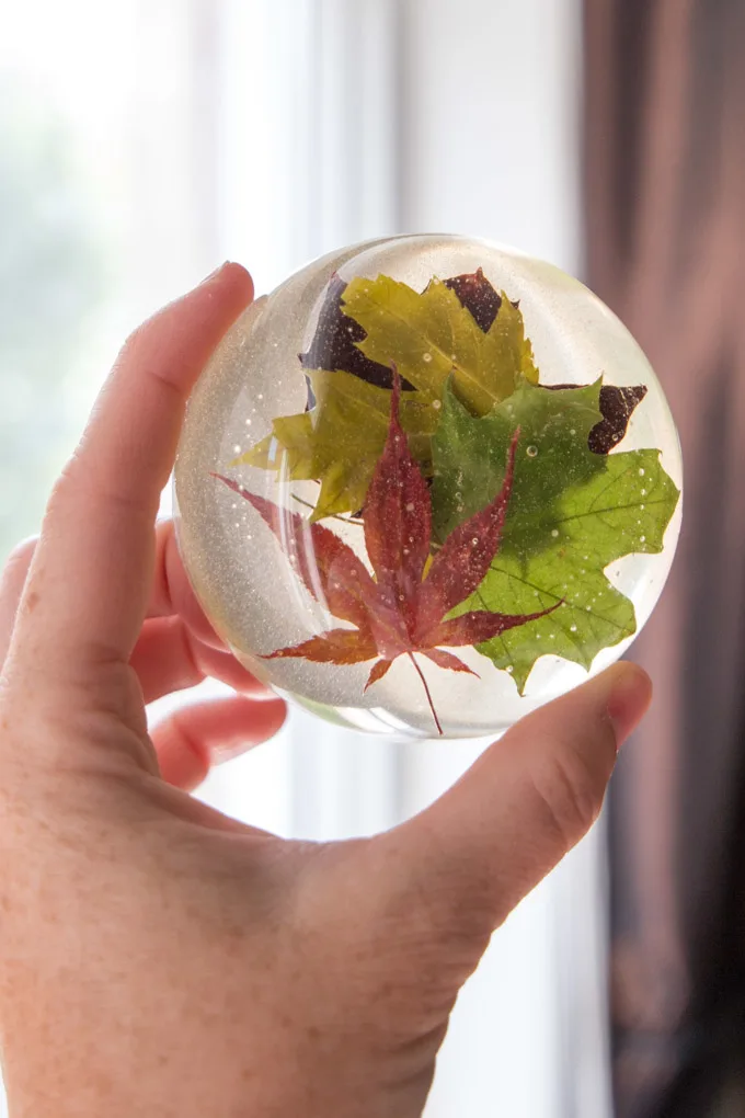 Beautiful nature-inspired resin paperweight made with real maple leaves. Full DIY tutorial included for this fall craft and office decor idea.