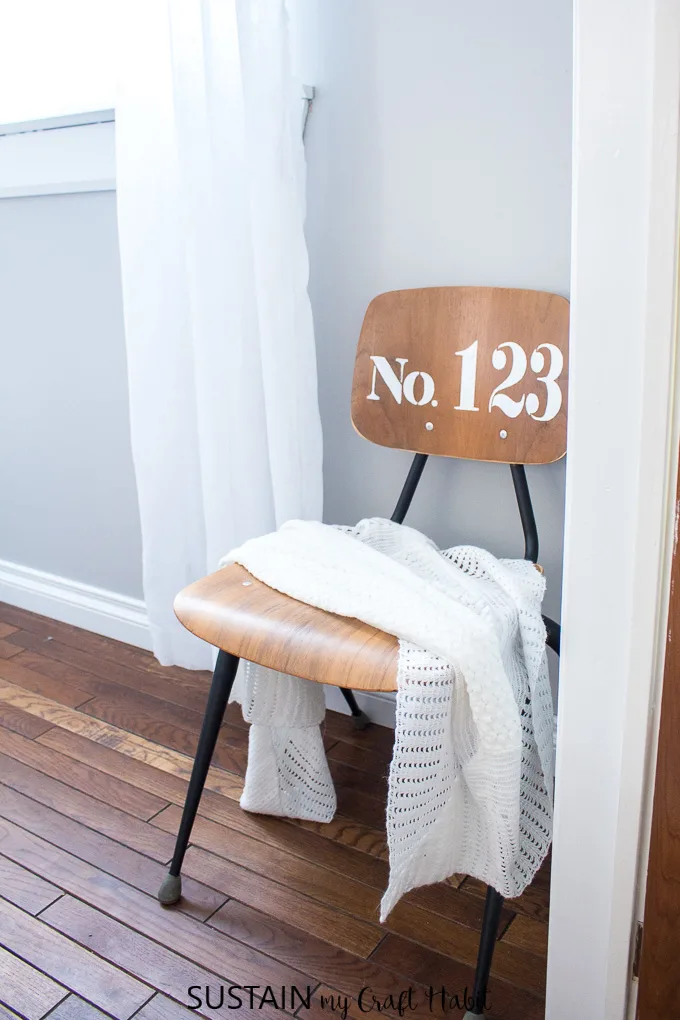 Learn how to refinish a wood chair with this step-by-step tutorial. Upcycled student chair with a farmhouse style stencil and black matte spray painted legs.