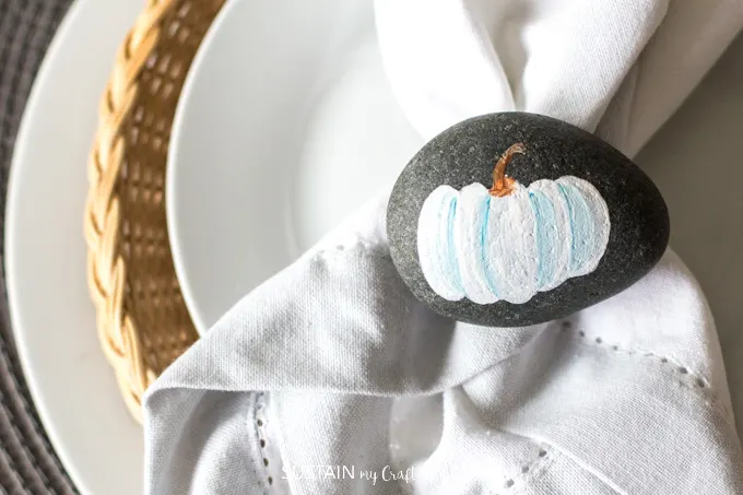 These painted pumpkin rocks make adorable Thanksgiving decor. Learn how to paint your own with this video tutorial plus other rock painting ideas. #paintedrocks #rockpaintingideas #diy #thanksgivingcrafts