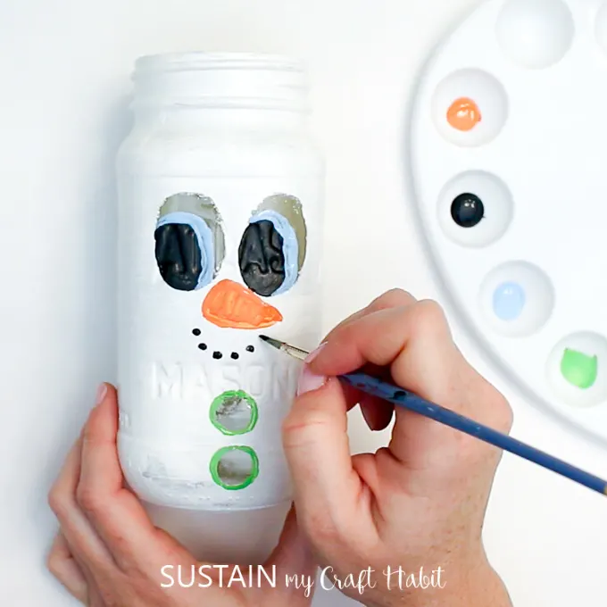 Painting a carrot nose onto the Ball jar snowman craft