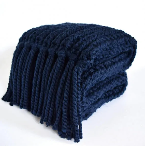 Folded navy blue knitted scarf with tassels.