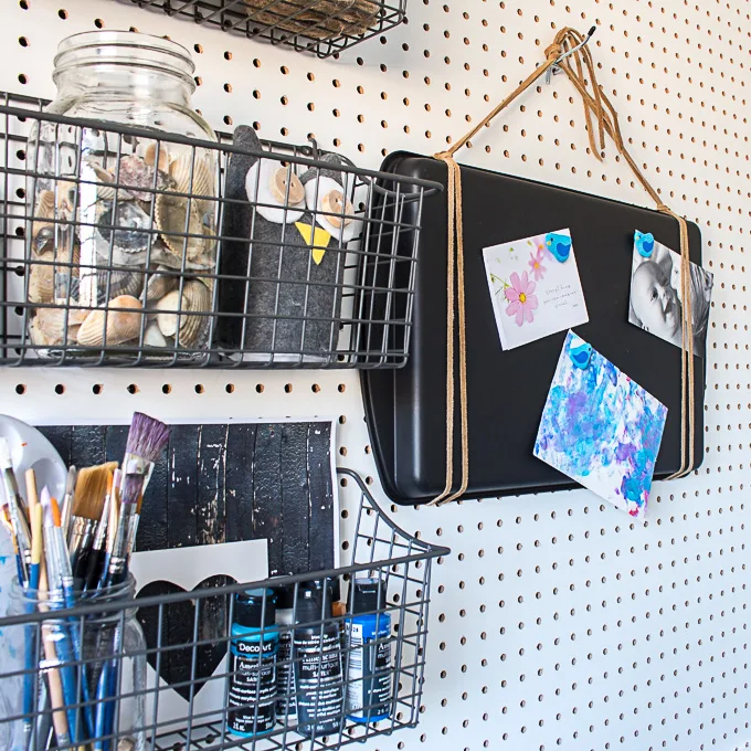 A white pegboard filled with crafting supplies including easy painted rocks crafts