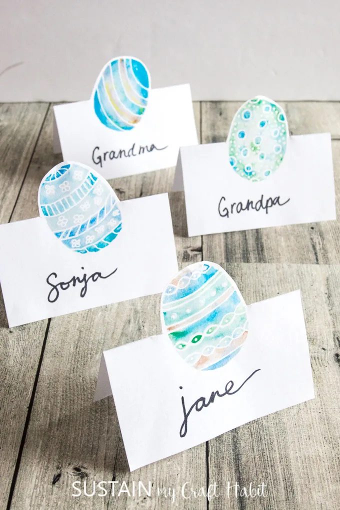 Four designs of Easter place cards in blues and greens