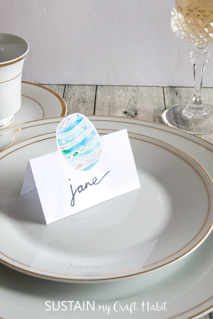 A beautiful Easter table setting with gold plates and an Easter egg name card.