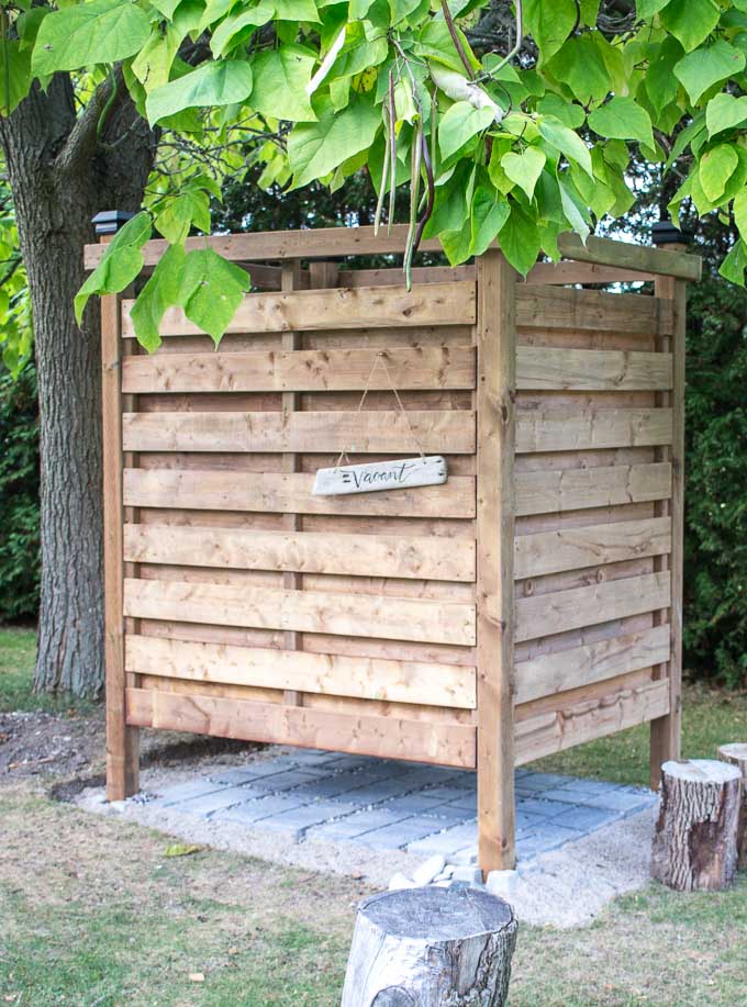 Outdoor shower made with wood slats under a tree