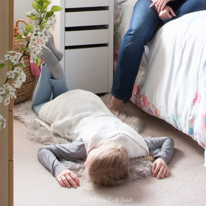 Girl laying on a faux sheepskin rug on her bedroom floor