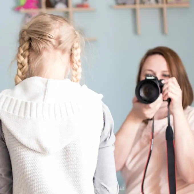 Mom taking a photo of her tween daughter