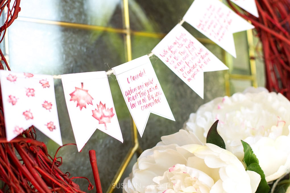 Pretty red grapevine wreath decorated with flowers and a small banner for Canada Day