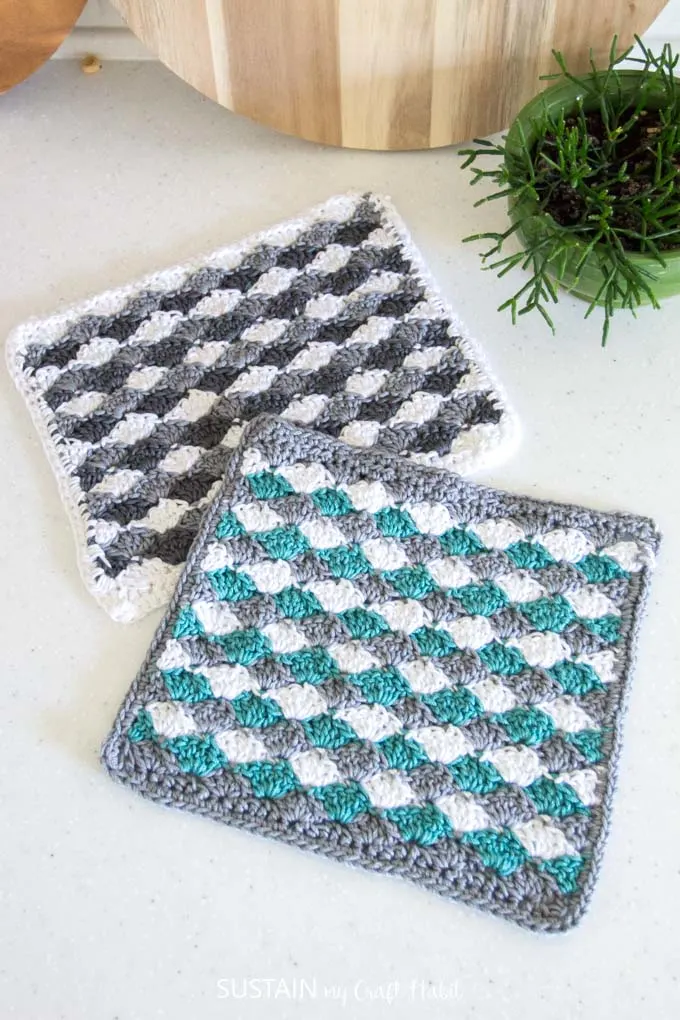 Completed grey, white and teal crochet dishcloths made with a free sea shells crochet pattern.