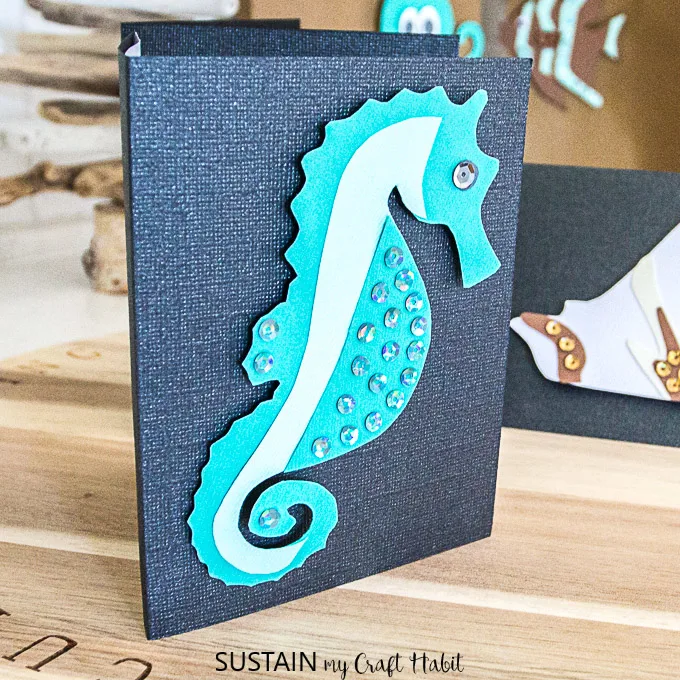 Beautiful handmade beach themed greeting card of a teal seahorse on a black texture notecard