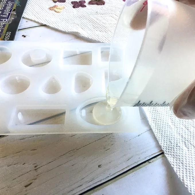 Pouring mixed resin solution into a silicone mold.