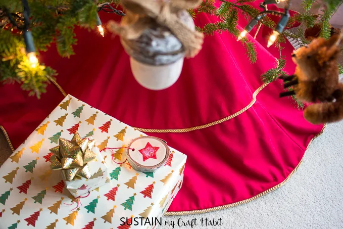 View from above of a red and gold Christmas tree skirt, under a tree with Christmas gifts