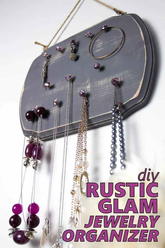 Wooden jewelry organizer hanging on a wall adorned with necklaces