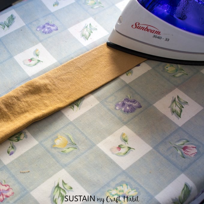 Ironing the art straps of a DIY apron pattern