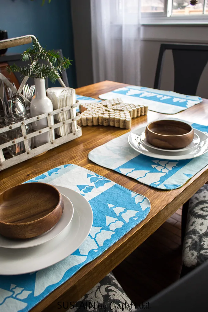 Beautiful wooden table set with handmade placemats in a rustic, winter theme