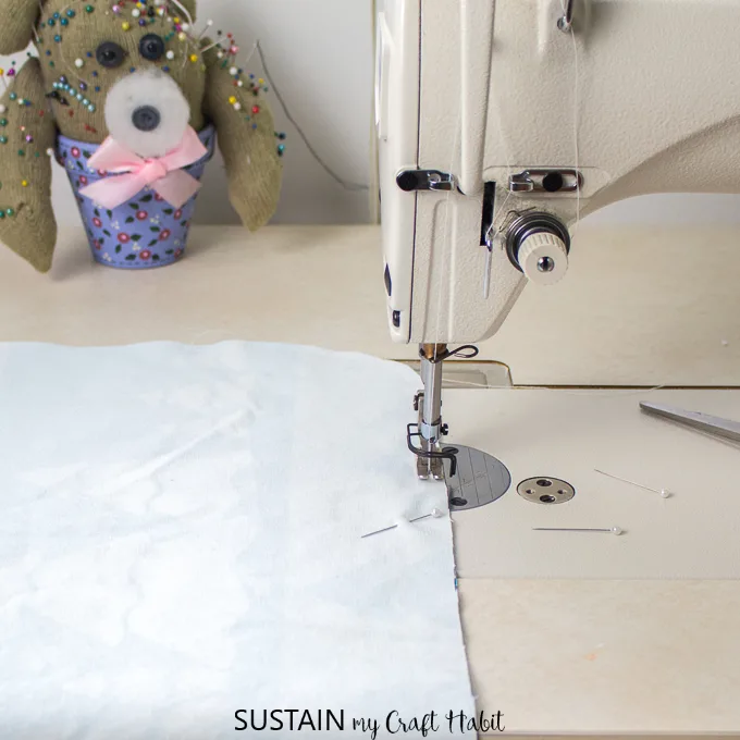 Stitching together two printed fabrics with a sewing machine to make placemats.