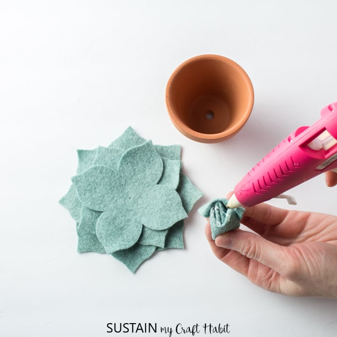 Felt succulent pattern pieces being glued together with a hot glue gun and clear craft glue