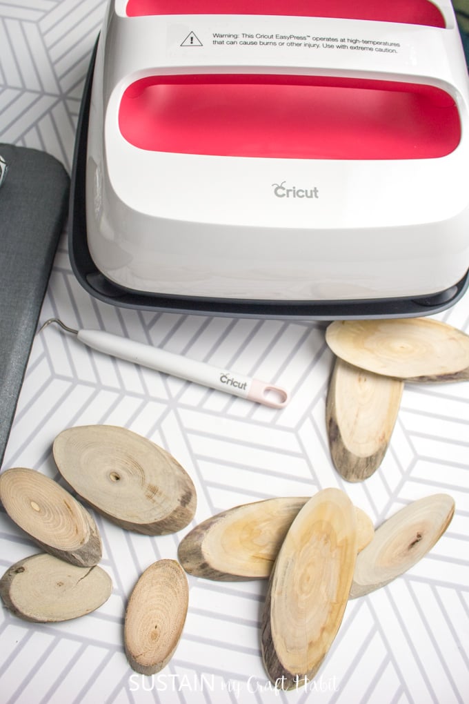 The medium sized Cricut Easy Press beside oval shaped wood slices.