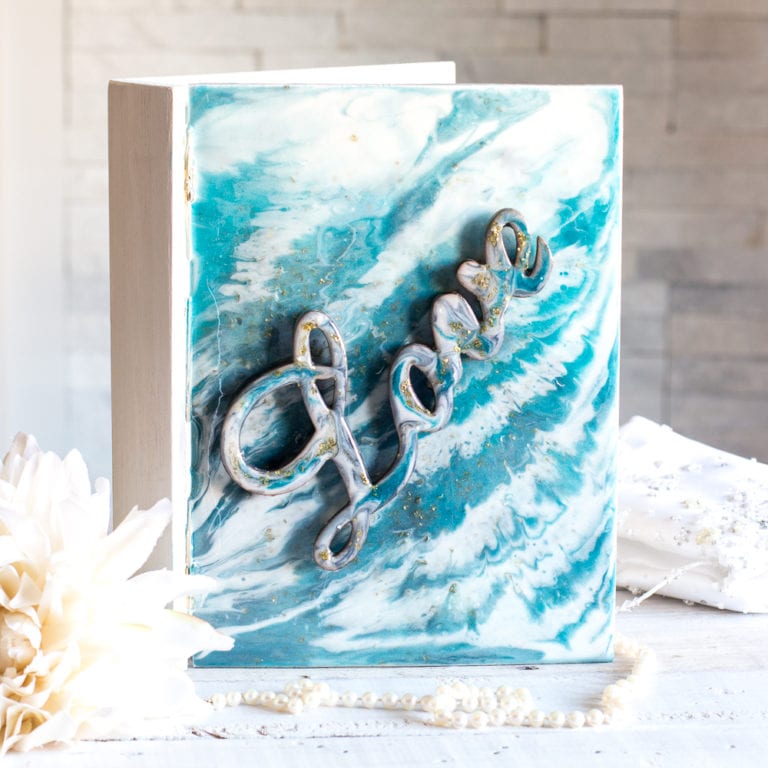 A wooden memento box with a resin poured cover in blues and whites