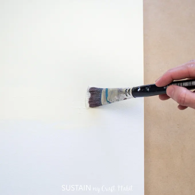 woman painting a canvas with "buttermilk color" paint