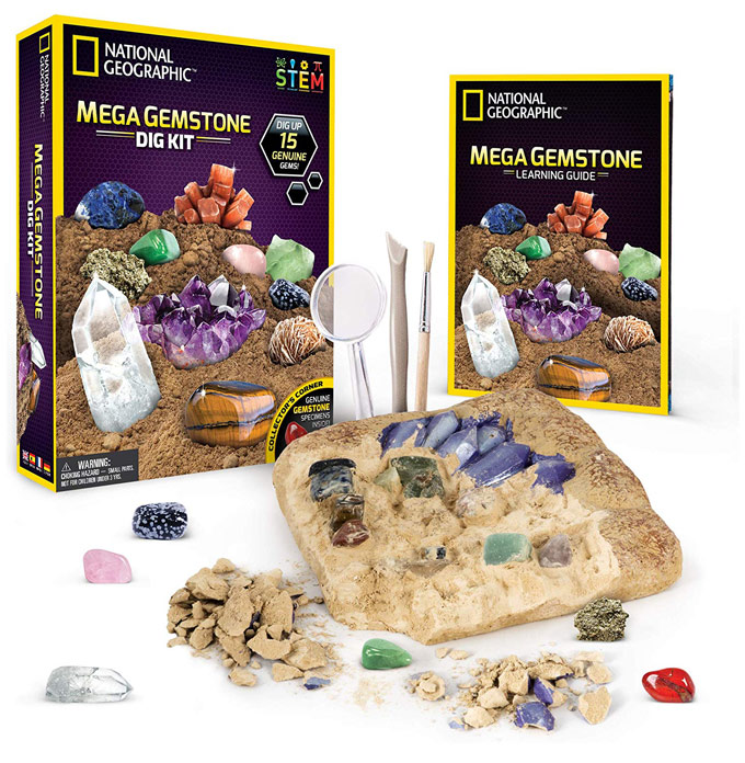 A mega gemstone kit showing a gemstone book, rocks, gemstones and tools.