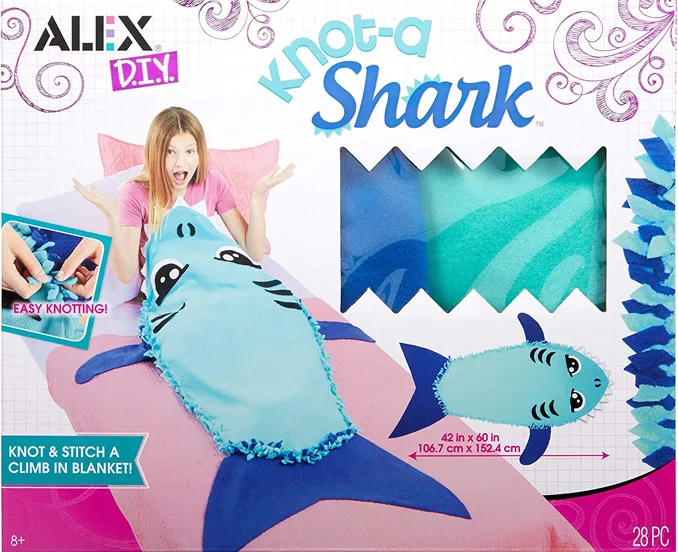 Felt fabric being used as a shark shaped blanket by a girl sitting in a bed.