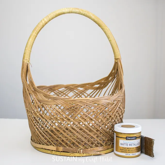 A wicker basket, Matte Metallics Gold paint and a paintbrush.