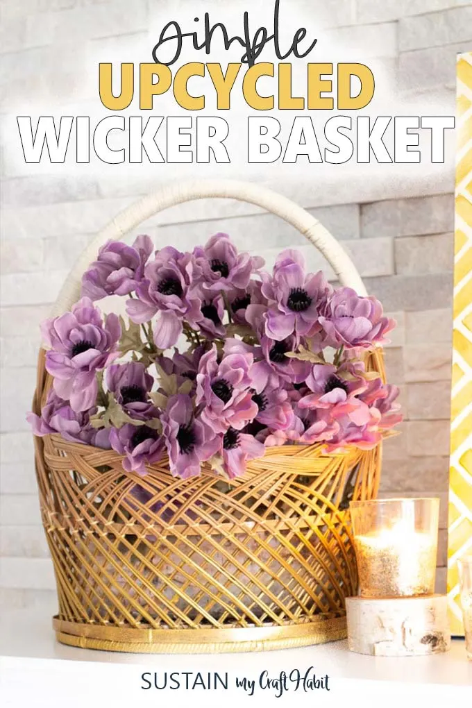 The words "simple upcycled wicker basket" above a close up of a gold painted wicker basket with purple flowers and one lit candle.