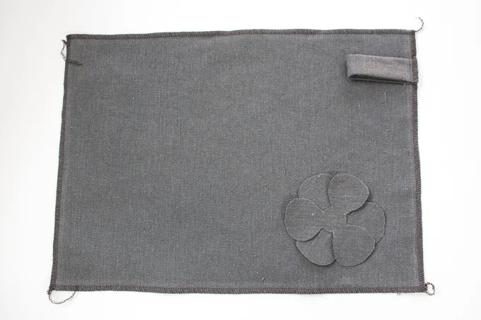 Placement of the flower embellishment on the handmade pencil case.