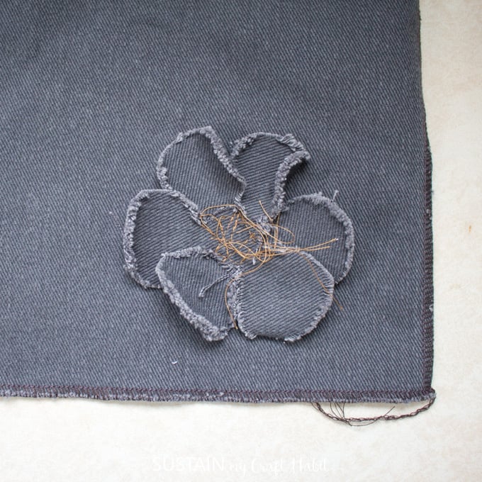 Close up image showing the frayed edges of the handmade flower embellishment.