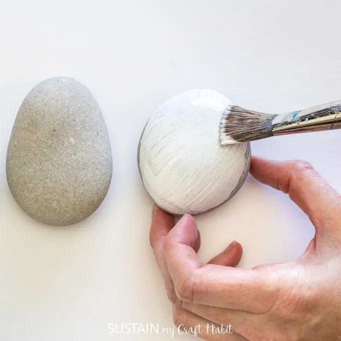 Painting one rock with white paint.