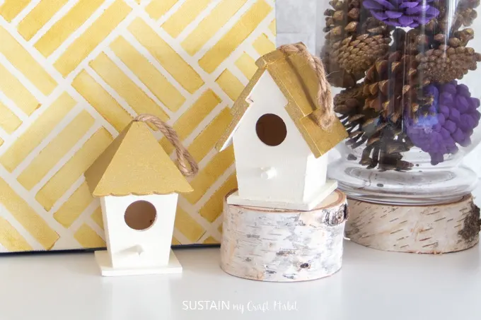 A close up view of two small birdhouses on the fall mantle.