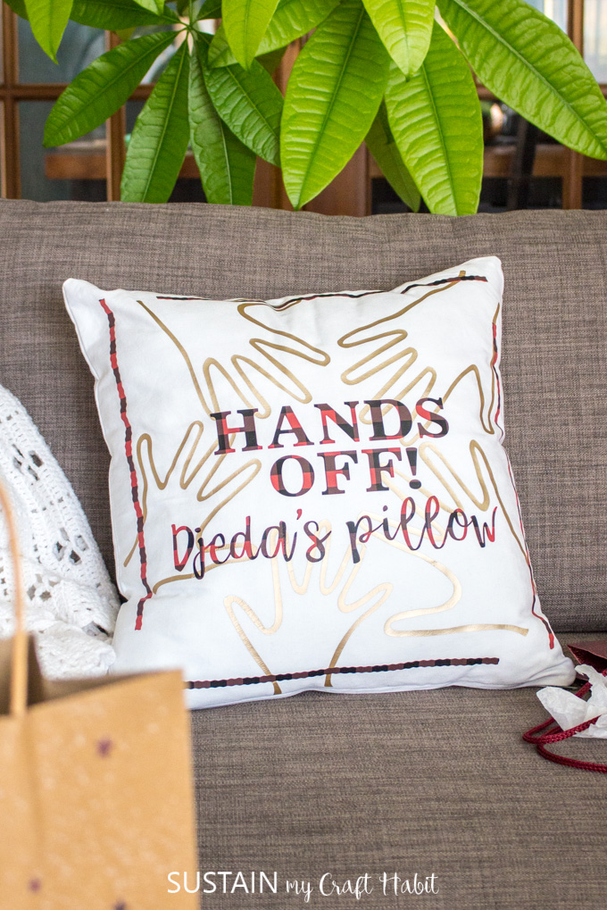A personalized throw pillow gift for grandpa made with the Cricut Maker on a gray couch.